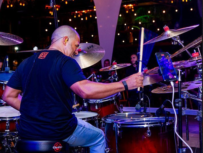 Alexandre Aposan tocando ao vivo, com luzes coloridas